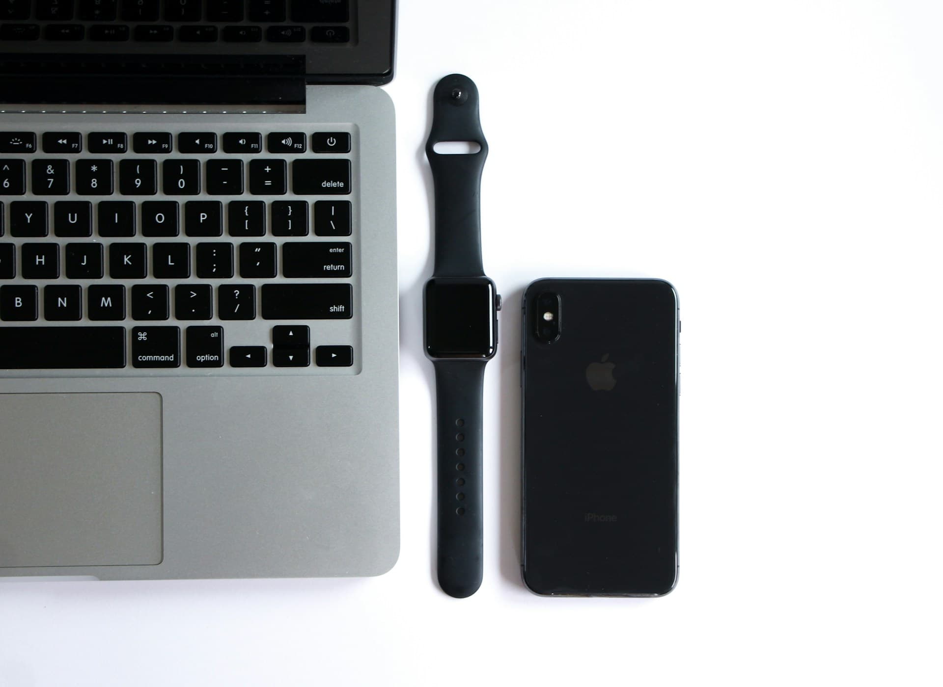 apple laptop, apple watch, and iPhone on table