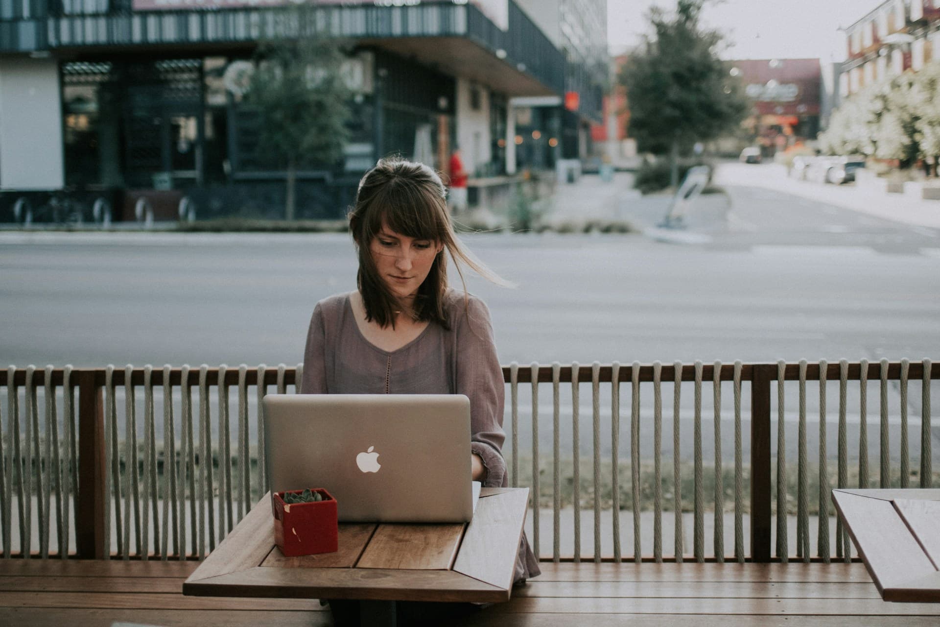 woman working on laptop at coffee shop receiving paypal scam alert
